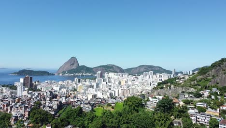paisaje de rio de janeiro - favela, edificios, mar y pao de acucar en el fondo - paisaje de luz del día por dron