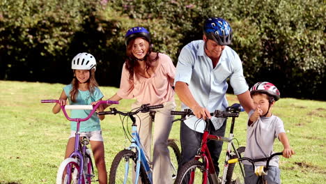 padres que muestran la dirección a los niños mientras viajan en bicicleta