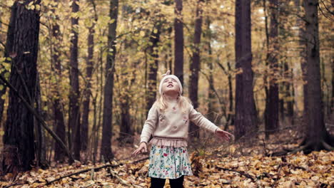 Joven-Arroja-Hojas-De-Otoño-En-El-Aire-En-El-Bosque-De-Otoño,-Cámara-Lenta