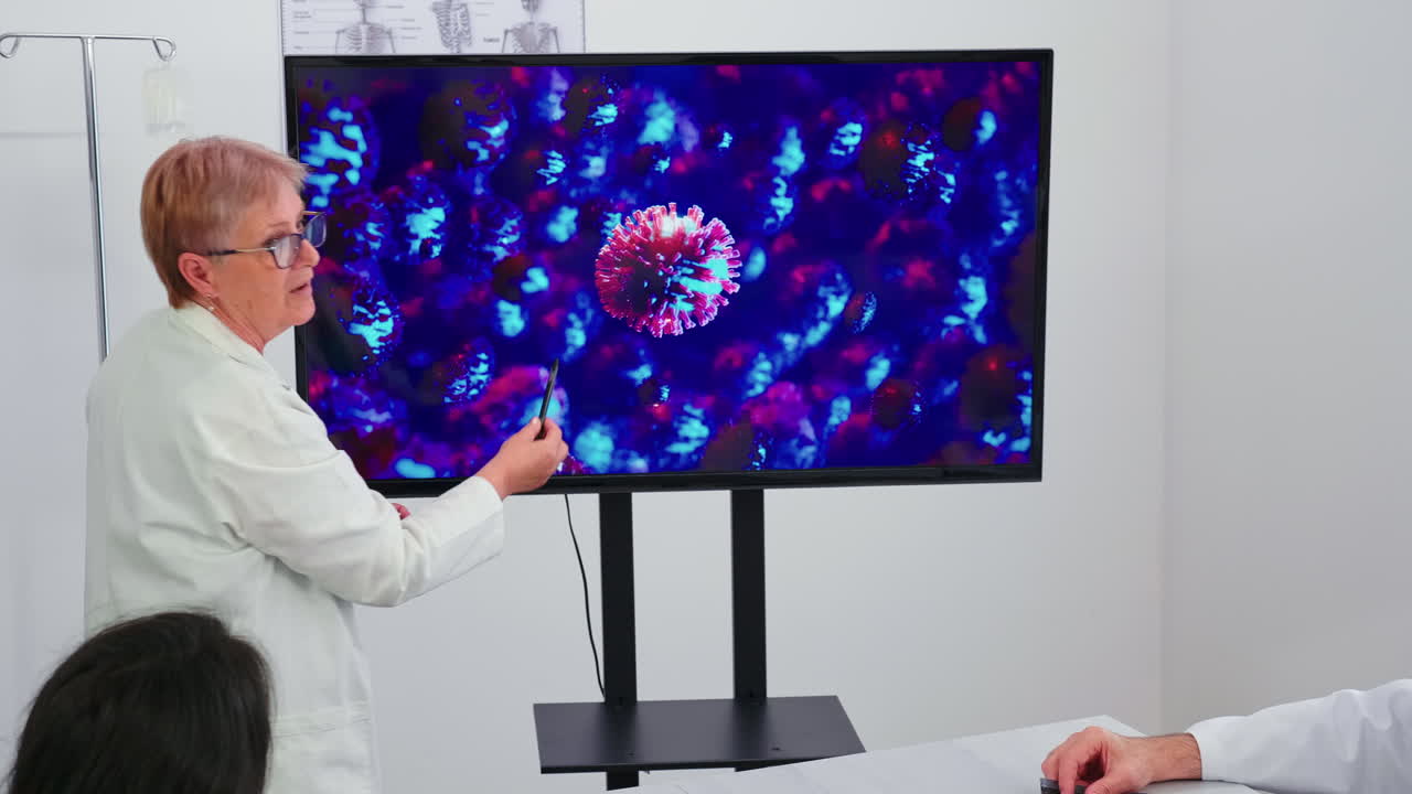 의료 전문가가 모니터를 사용하여 코로나바이러스 백신에 대해 이야기합니다.