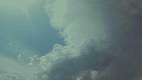 time lapse a developing threatening storm cloud in a blue sky, with the sun rays on the left top