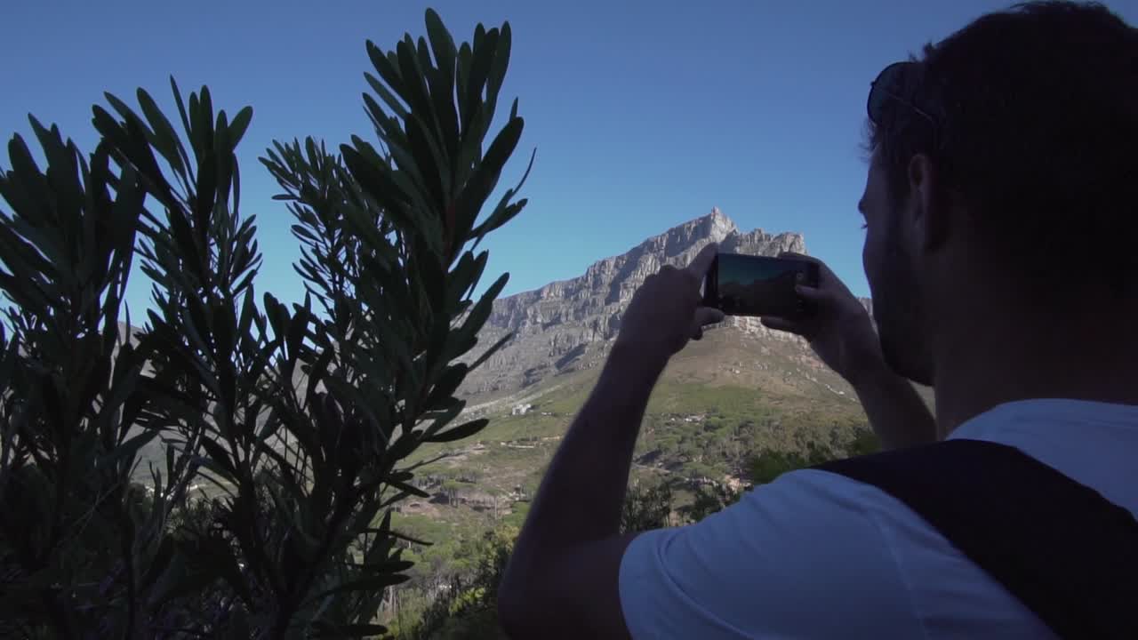 Man taking a picture with his phone of Table Mountain in Cape Town, South Africa in Slow Motion