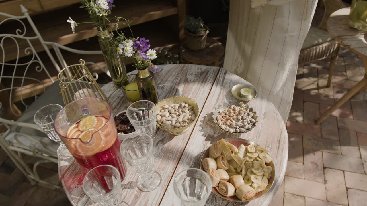 Person arranging snacks and drinks on an outdoor table