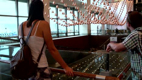 a woman and man looks at the kinetic rain at the singapore airport