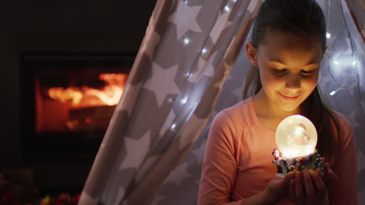 행복한 백인 소녀가 크리스마스에 눈구 ⁇ 으로 놀고 있습니다.