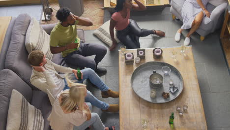 overhead shot of disappointed multi-cultural group of friends watching sports game on tv at home