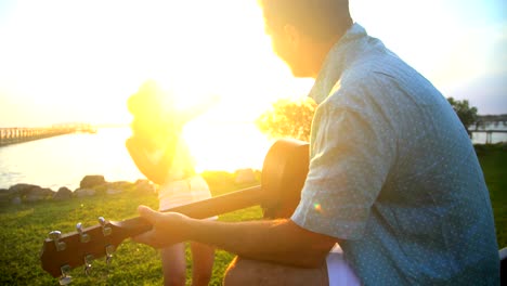 latin american woman photographing caucasian man playing guitar