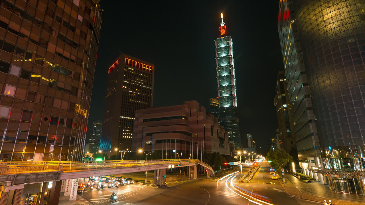 toma de lapso de tiempo del tráfico en la carretera en el centro de la ciudad de taipei con la torre 101 en el fondo - luces intermitentes durante la noche oscura en taiwán