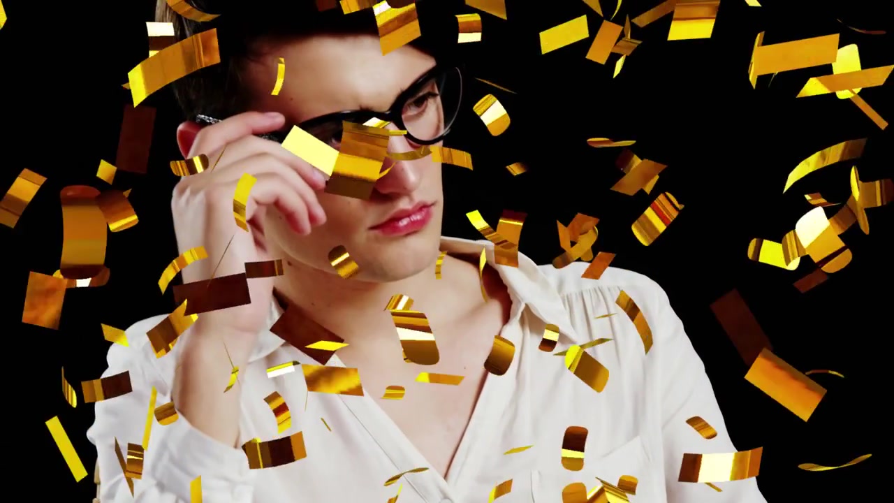 Modello uomo seduto in studio, confetti dorati che cadono e rivelano il volto per la moda, regolando gli occhiali