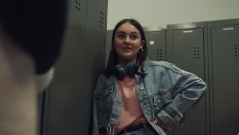 Student-girl-flirting-classmate-standing-near-lockers-school-corridor-close-up.