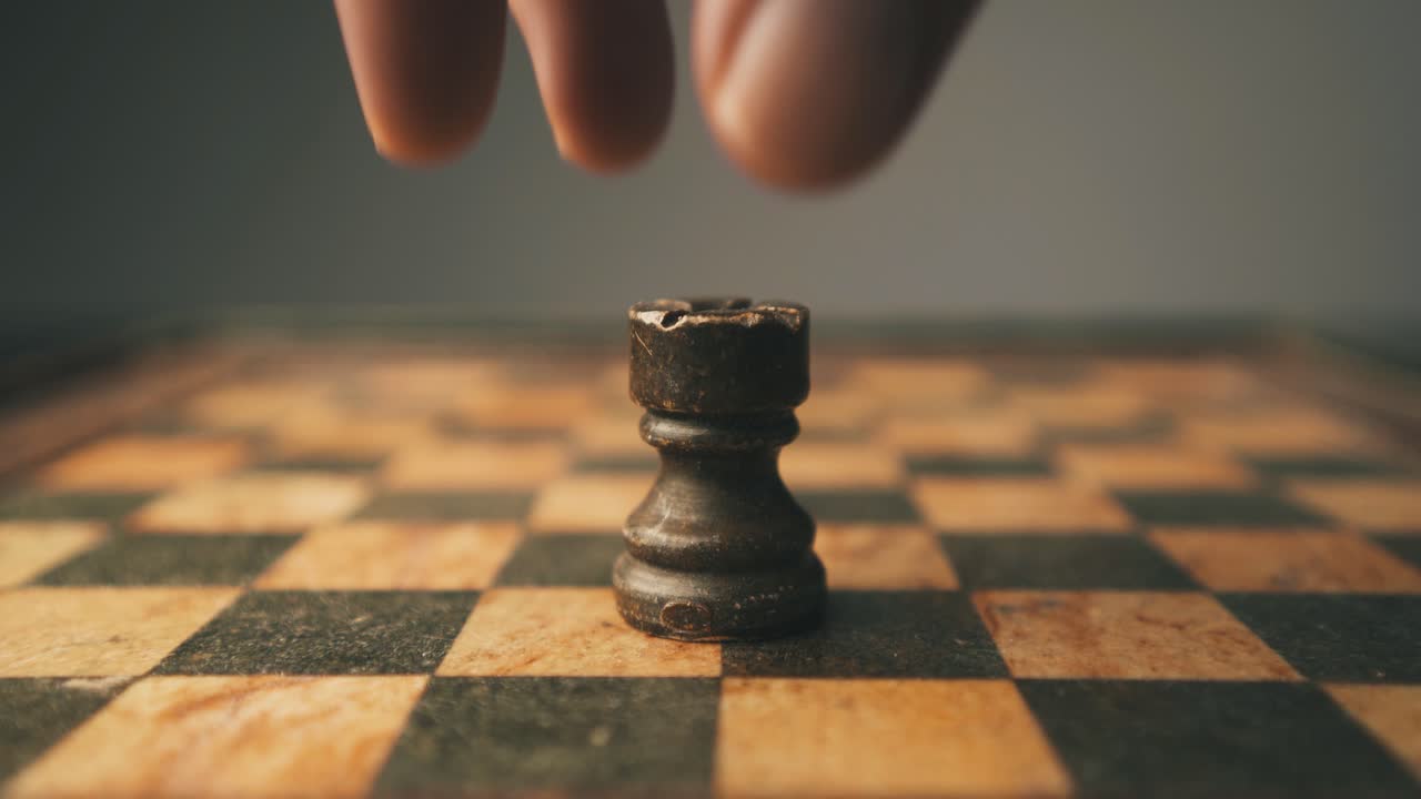 Close-up shot of rook chess piece being placed on game board