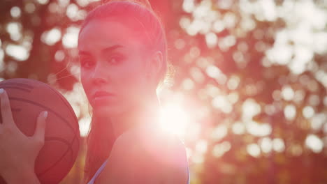 closeup beautiful woman training street basketball in sport playground.