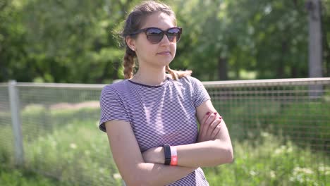 portrait of an attractive smiling caucasian woman in a park with glasses