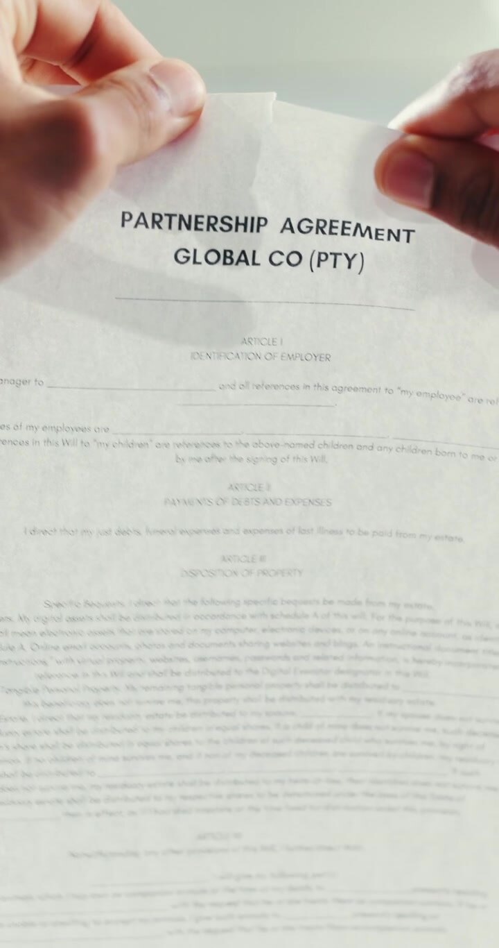 Person Tearing Up a Partnership Agreement Document