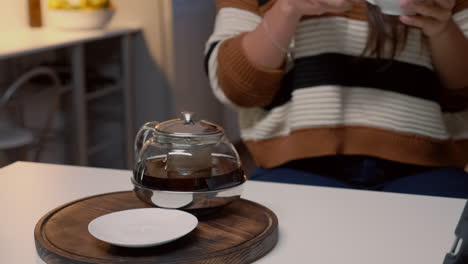 Cup-of-tea-and-kettle-sitting-on-kitchen-white-table