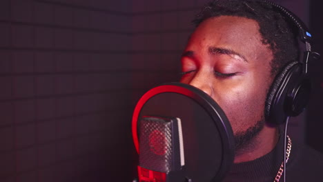 man singing into microphone in recording studio