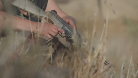 Camouflaged-female-soldier-standing-guard-with-submachine-gun-in-hand