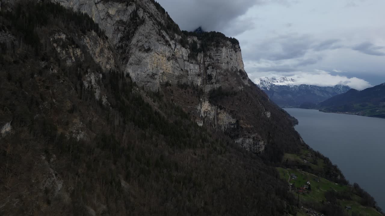 tomada de avión no tripulado de montañas cubiertas de nieve por el acantilado de colinas en primer plano en walensee, suiza