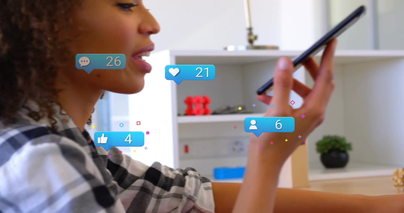 Marketer using laptop grabbing phone speaking as social media bubbles climbing showing engagement