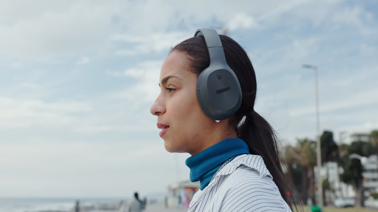 mujer escuchando música en la playa