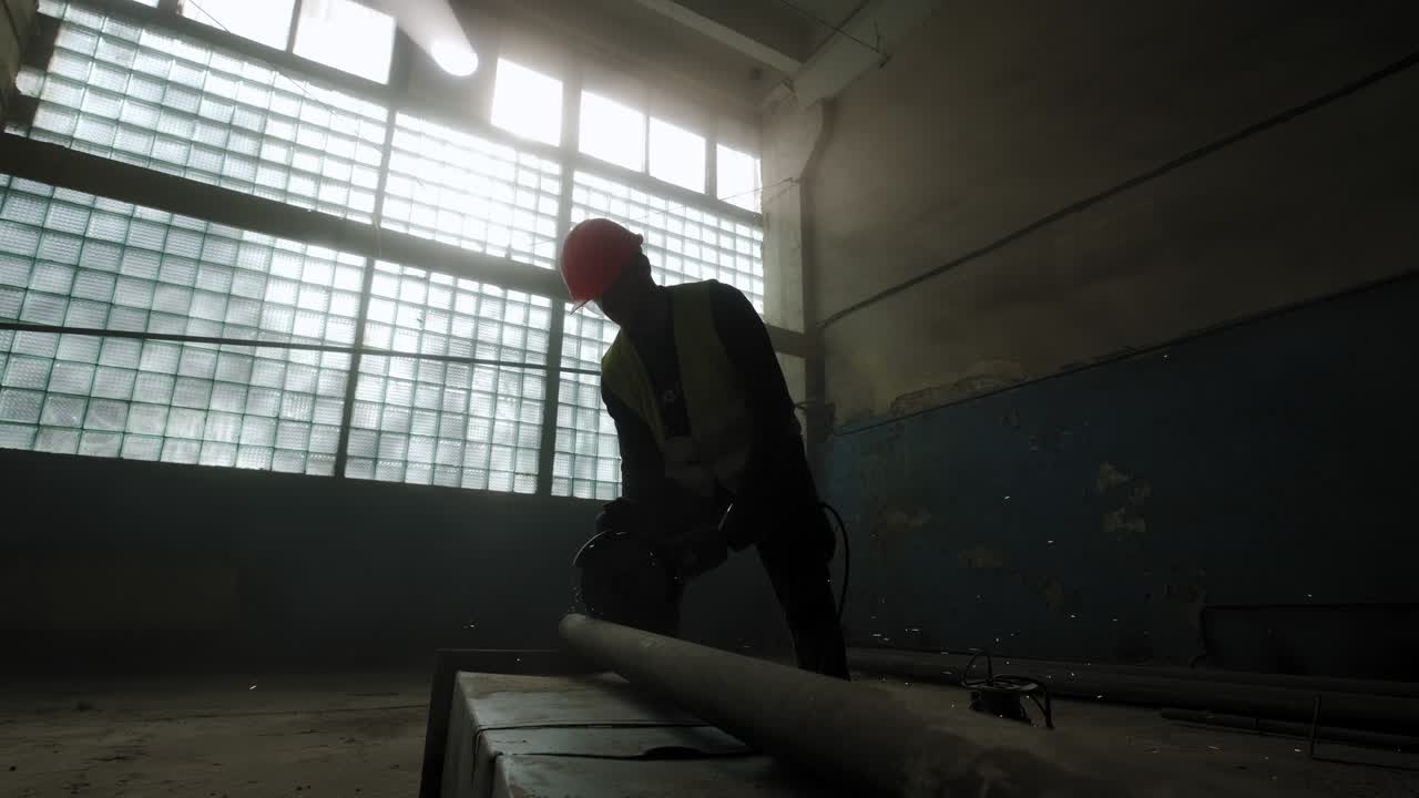 Wide view of Construction worker cuts steel with a circular saw, construction worker's feet, flying sparks from a circular saw. Slow motion