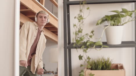 reflection in mirror of joyful young blond-haired man dancing