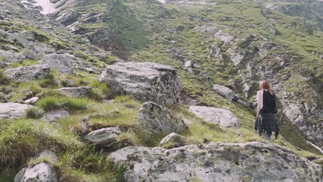 a young woman hiker climbs mountains with photo camera. transfagarasan, carpathian mountains in romania