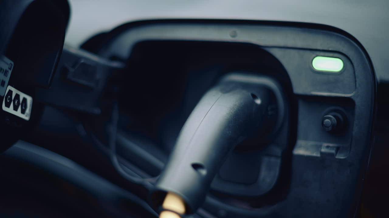 Electric vehicle plugged into charging port in daylight