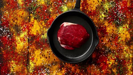 carne en una sartén sobre una superficie con especias derramadas