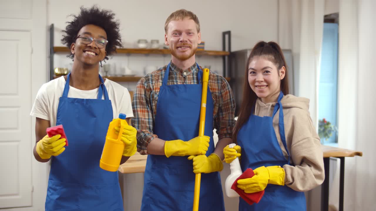 Multiethnic team of professional janitors in uniform indoors.