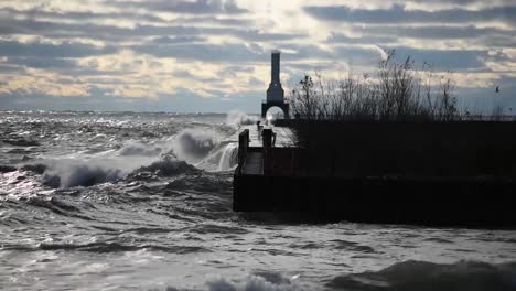 huge tides from the sea crash into sea wall creating and explosion of waves