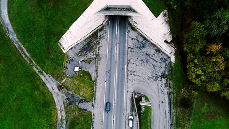 vista aérea sobre el túnel de la autopista de entrada en francia. sólo campos de hierba y árboles alrededor de las carreteras. coches y camiones conduciendo en las carreteras