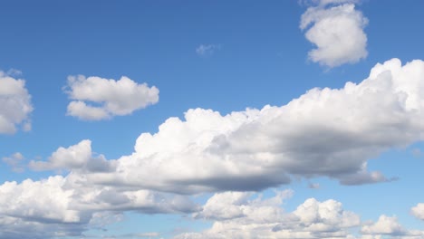 dynamic cloud formations drift over a clear blue sky