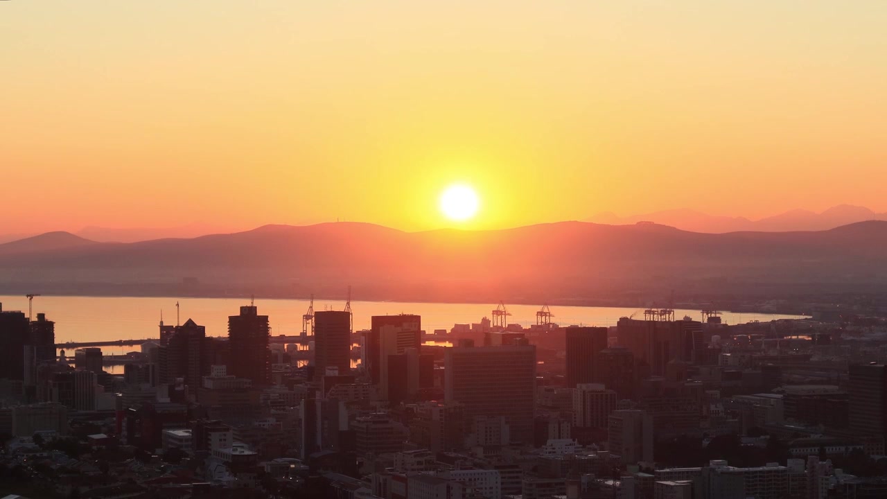 O sol nasce sobre a cidade da Cidade do Cabo, África do Sul. O porto na Baía da Mesa pode ser visto atrás dos edifícios da cidade