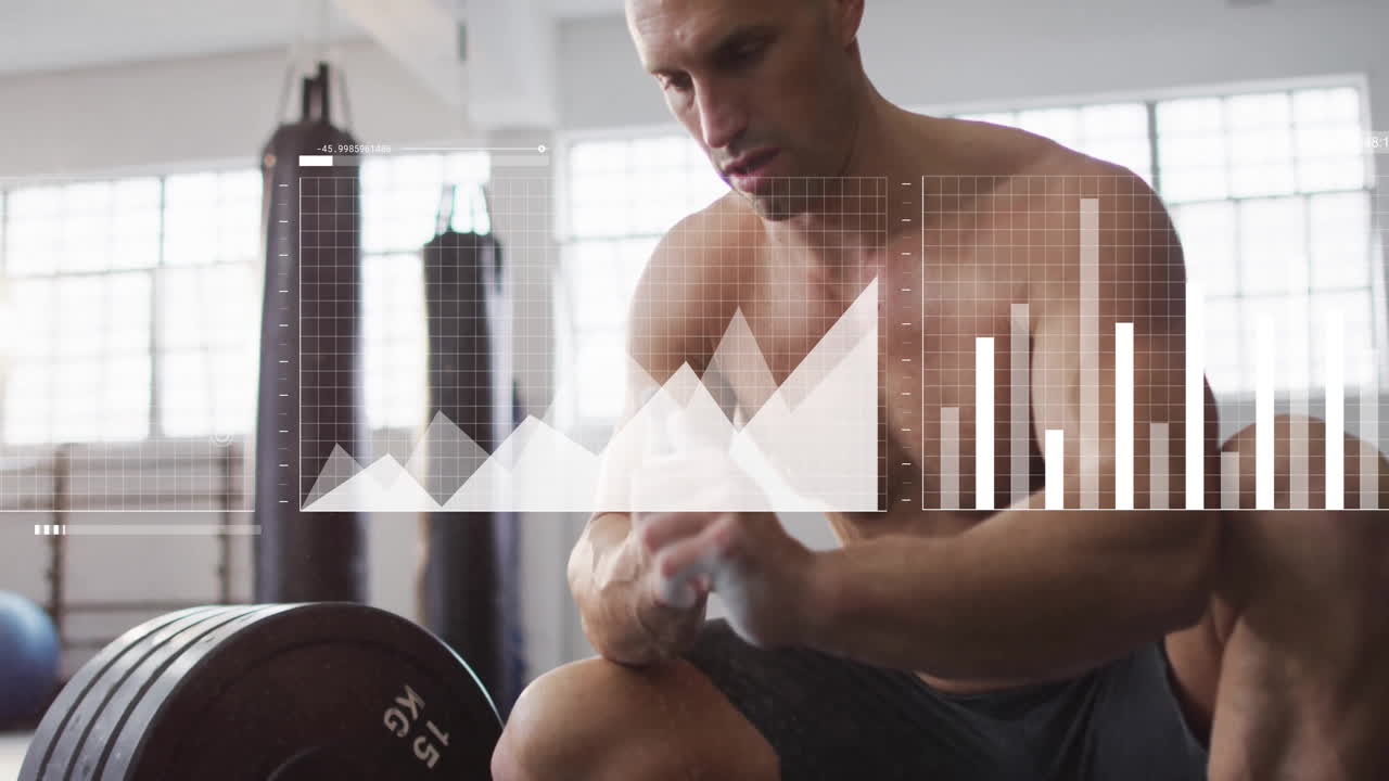 In gym, shirtless man exercising with animation of data charts on screen