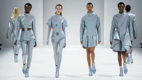 futuristic fashion showcase: a captivating glimpse of models strutting down the runway in stunning shimmering outfits that blend style with high-tech aesthetics