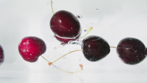 cerezas rojas cayendo en el agua