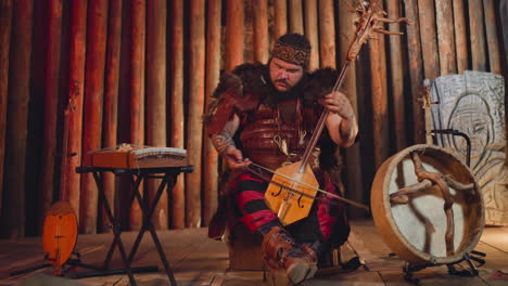 musician in traditional suit plays igil at folk concert