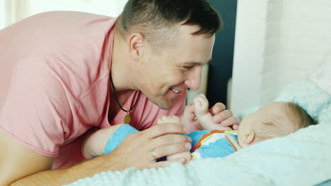 young father smiling happily to his baby he looks at it close-up