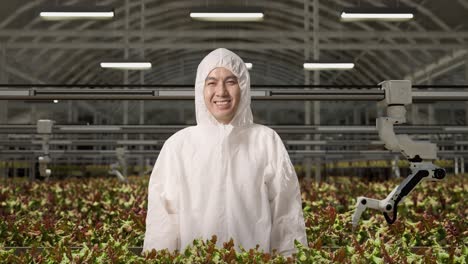 smiling worker in automated hydroponic greenhouse