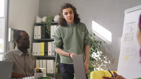 Young-Man-Giving-Presentation-to-Business-Team-at-Meeting