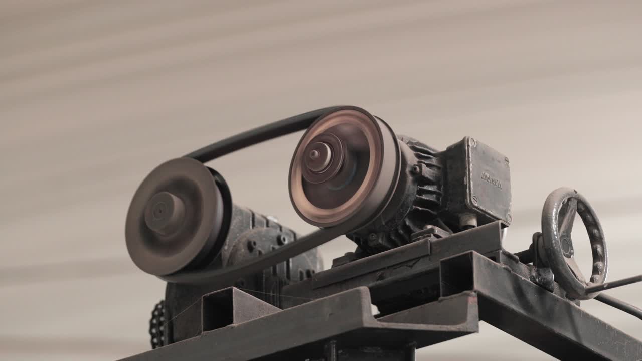 вращающееся металлическое колесо с ремнем двигателя на заводе