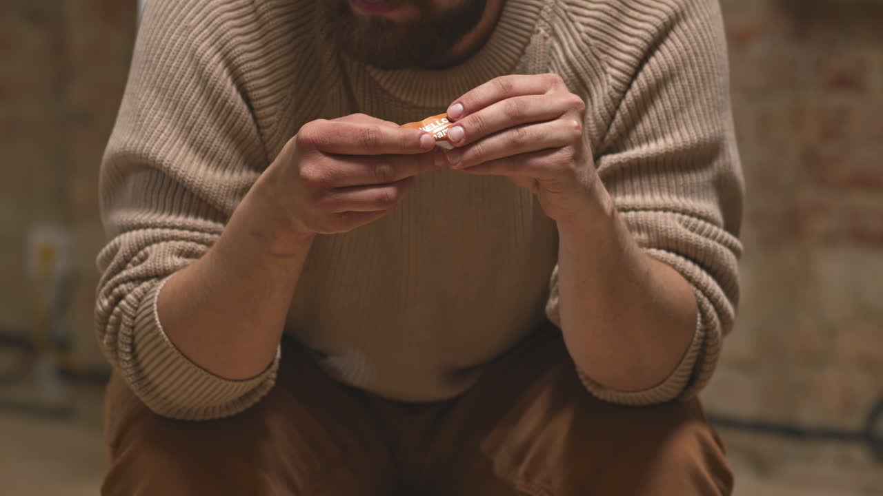 Depressed Man Crumpling Name Tag in Hands at Therapy Session