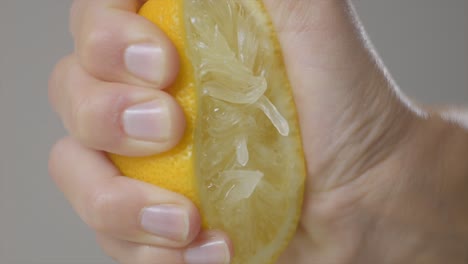 macro shot of gentle hand squeezing juicy yellow lemon, pulp