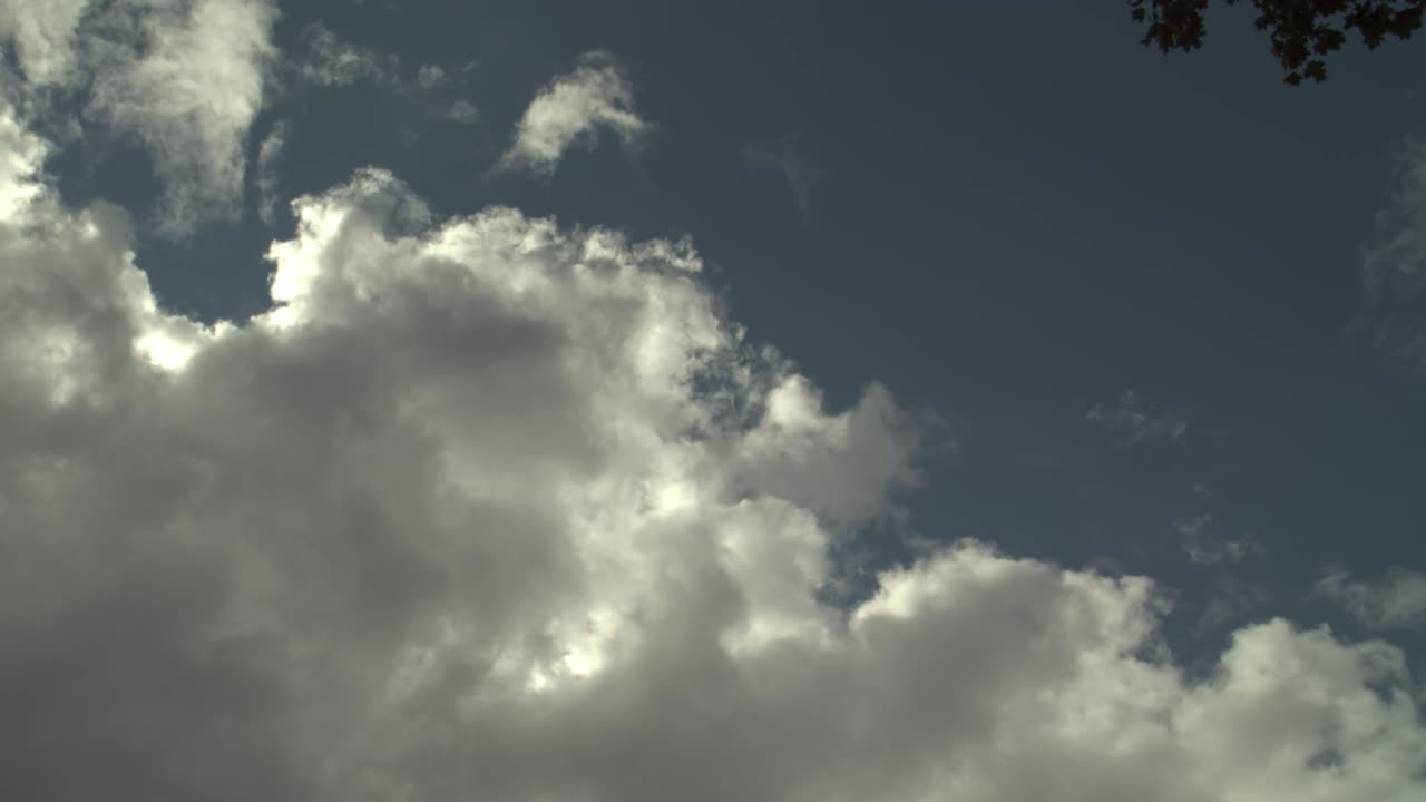 극적인 굴곡 구름, 스카이 라인을 가진 건물 구름, 어두운 극적인 비 구름이 지나가는 색, 부풀어 오른, 은, 어리 구름, 구름이 구름이 많은 여름날에 파란 하늘을 가로질러 태양을 가로막고, 밝은 태양이 빛나는 구름 풍경.