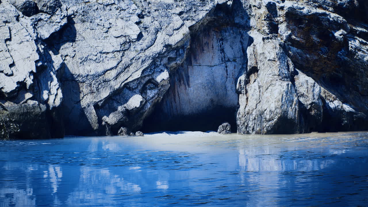 Rocky shoreline and calm blue water create a serene seaside view