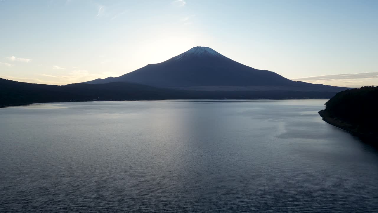 Beautiful drone flight over Mt. Fuji silhouette over Lake Yamanakako at sunset