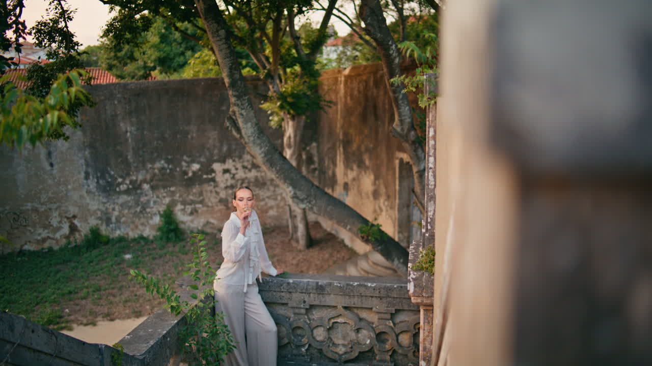 버려진 오래된 궁전에서 페인을 마시는 꿈 같은 여자.  와인을 맛보는 소녀