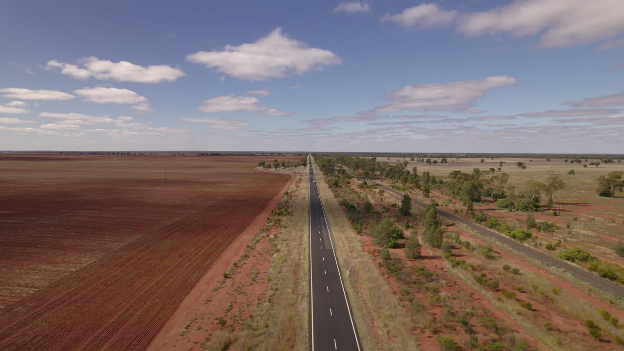 un vehículo solitario viaja por una carretera en el interior de australia desde un horizonte infinito